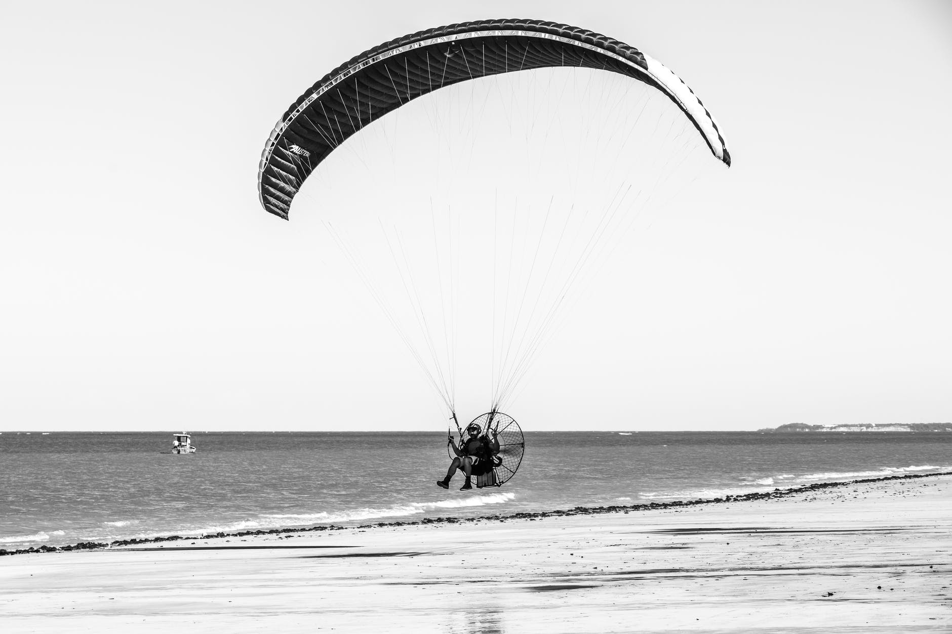 grayscale photo of powered paragliding flight